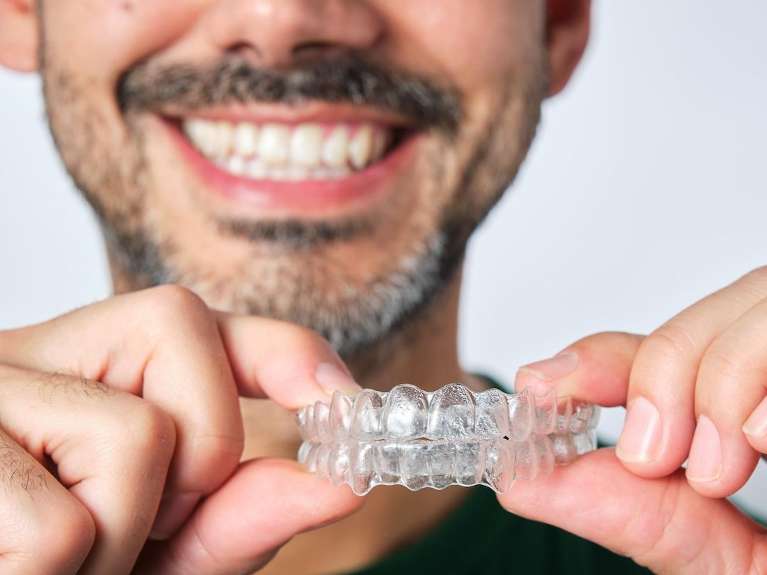 clear aligners west seattle | man holding aligners